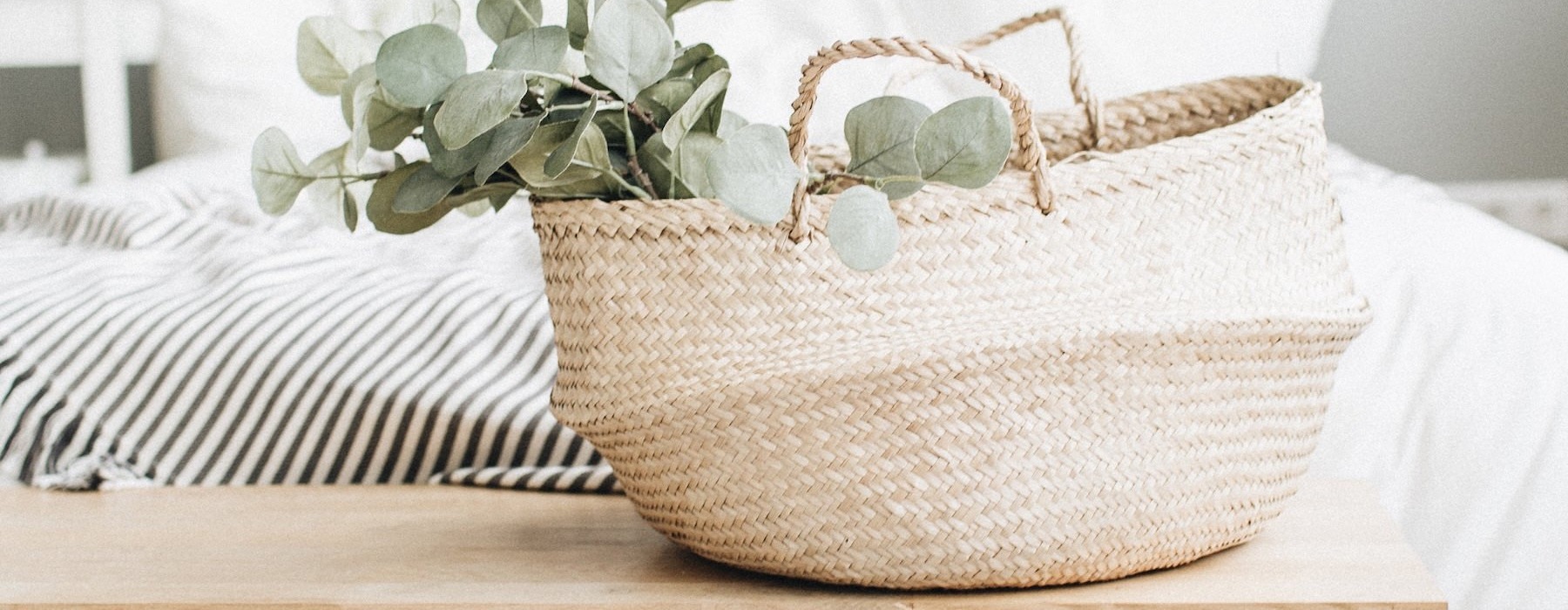 a basket on a table in front of a bed