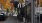 a person opening a store front on a shady street
